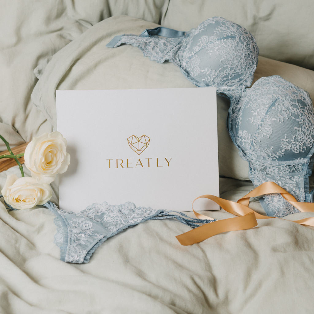 Pale blue lace lingerie set beside a Treatly gift box